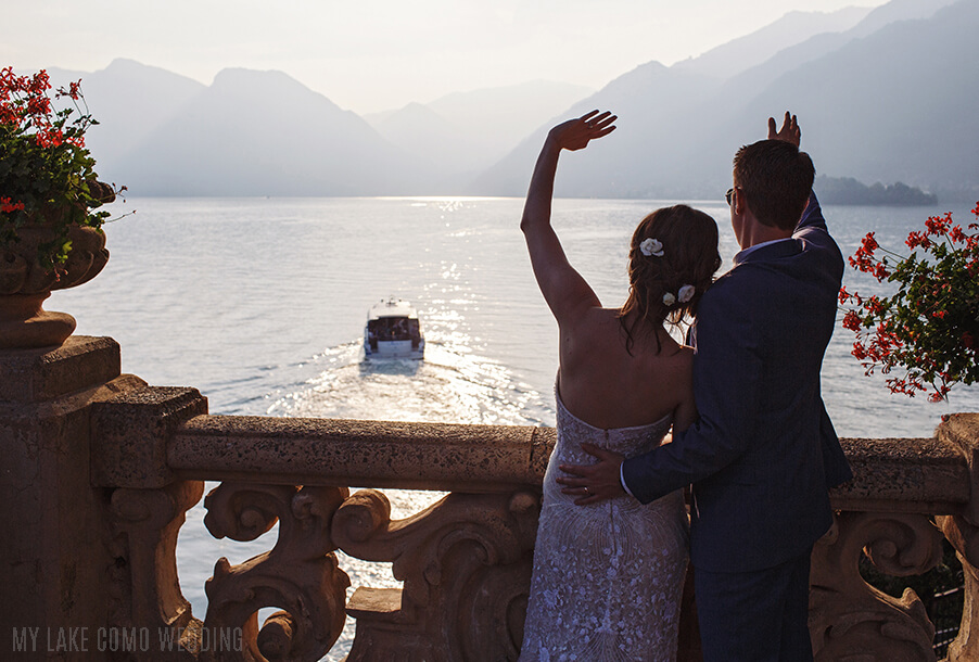 bride-and-groom-wave-to-their-wedding-guests-on-the-wedding-guest-boat-on-lake-como